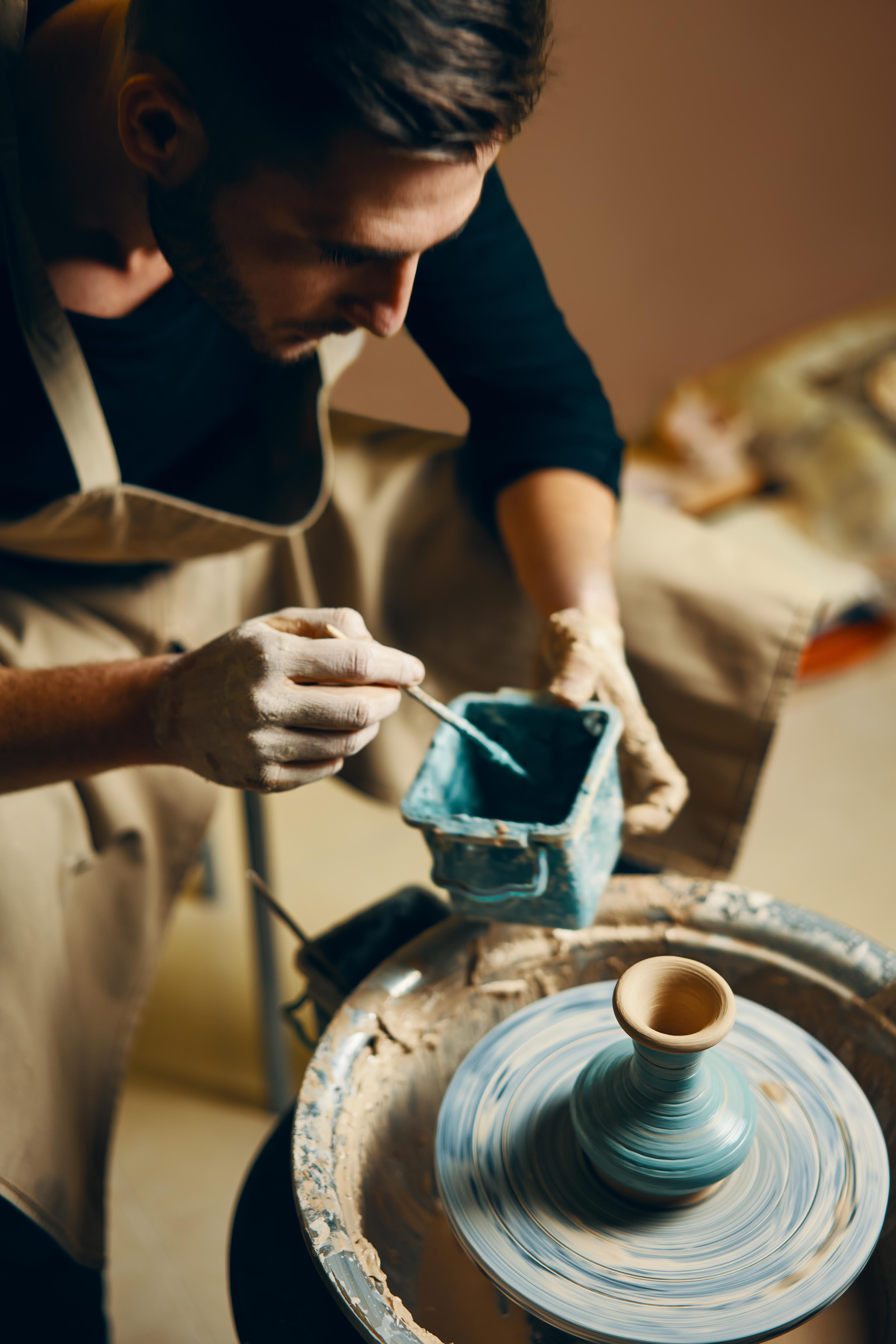 Man painting handmade ceramic